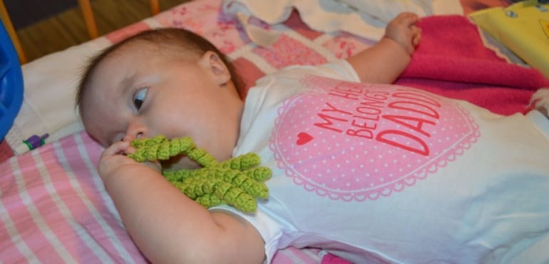 Little baby holding green toy