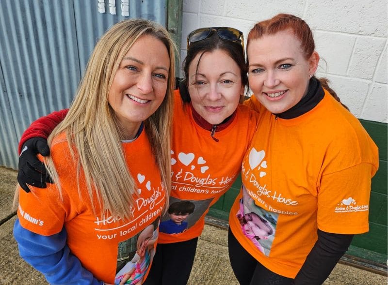 Angel Mums - Rachel in centre all 3 angel mums smiling to camera in orange tshirts