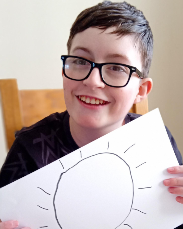 Nathan Nathan holding up his drawing of the sun