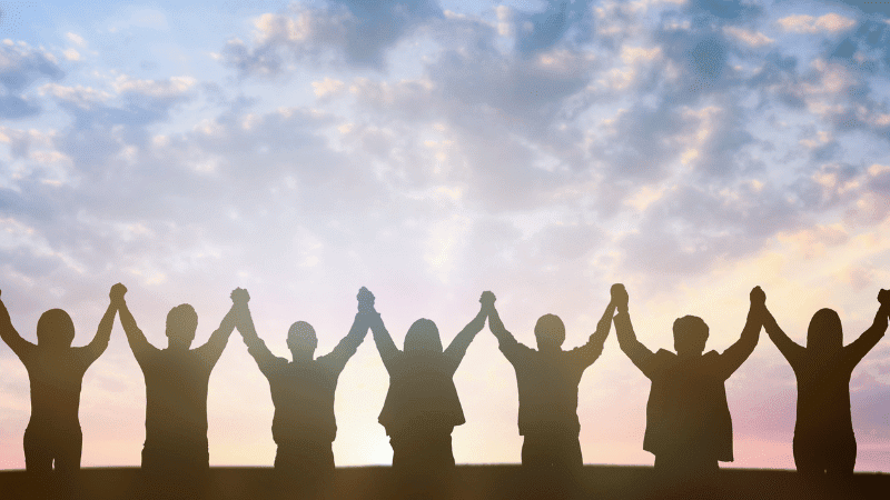 Divi Blog body images (19) A photo of people holding hands in the air.