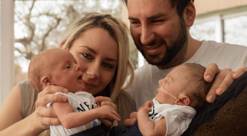 Roman's family Twin baby boys held by their mum and dad.
