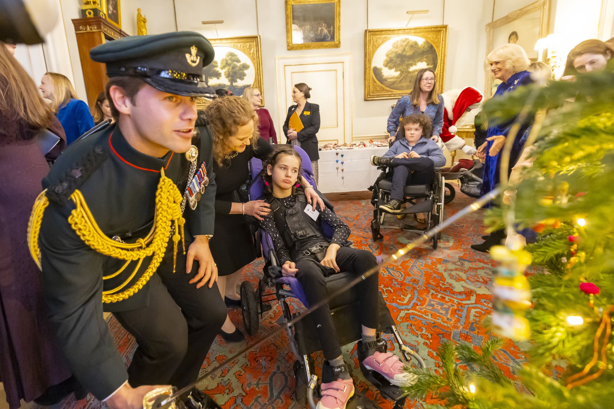 IJP-12-12-24-CHTree-0154 Equerry putting decorations on the tree with the Queen