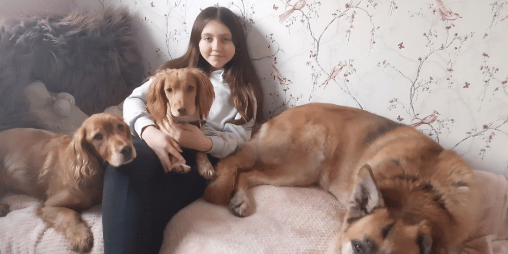 A photo of a girl with three dogs.