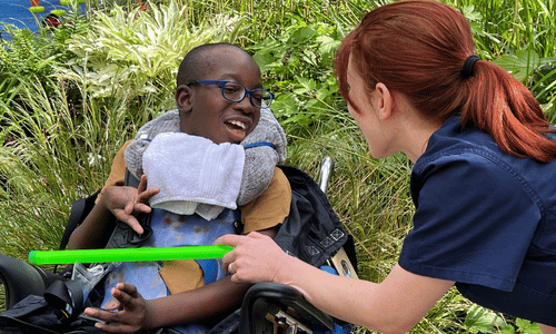A young boy smiling and playing with an ipad