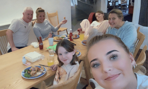 A young boy smiling and playing with an ipad