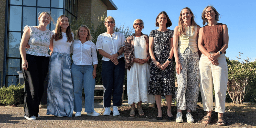 8 woman standing together and smiling