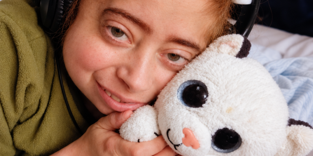 A young boy cuddling a white toy tiger.